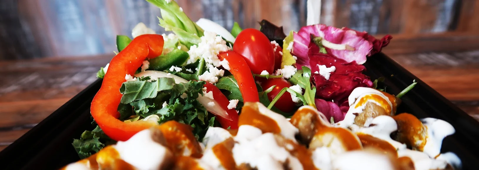 A close look at our salad with leafy greens, tomatoes and feta